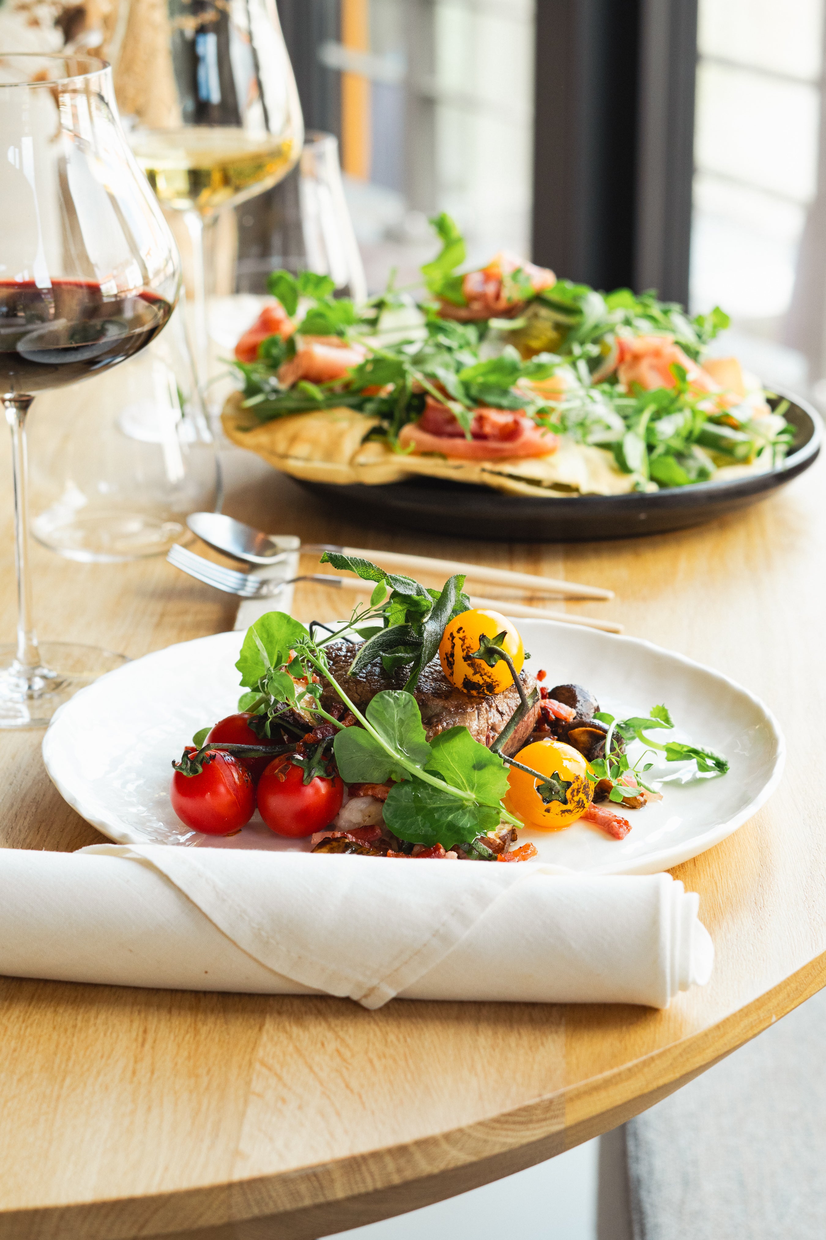 Gerecht met vlees, tomaten en sla, verfijnd gepresenteerd op een bord in een sfeervol restaurant